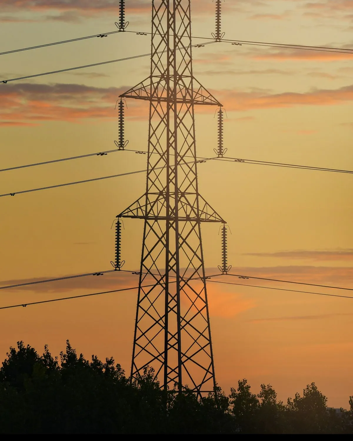 High-voltage pylon against a sunset sky