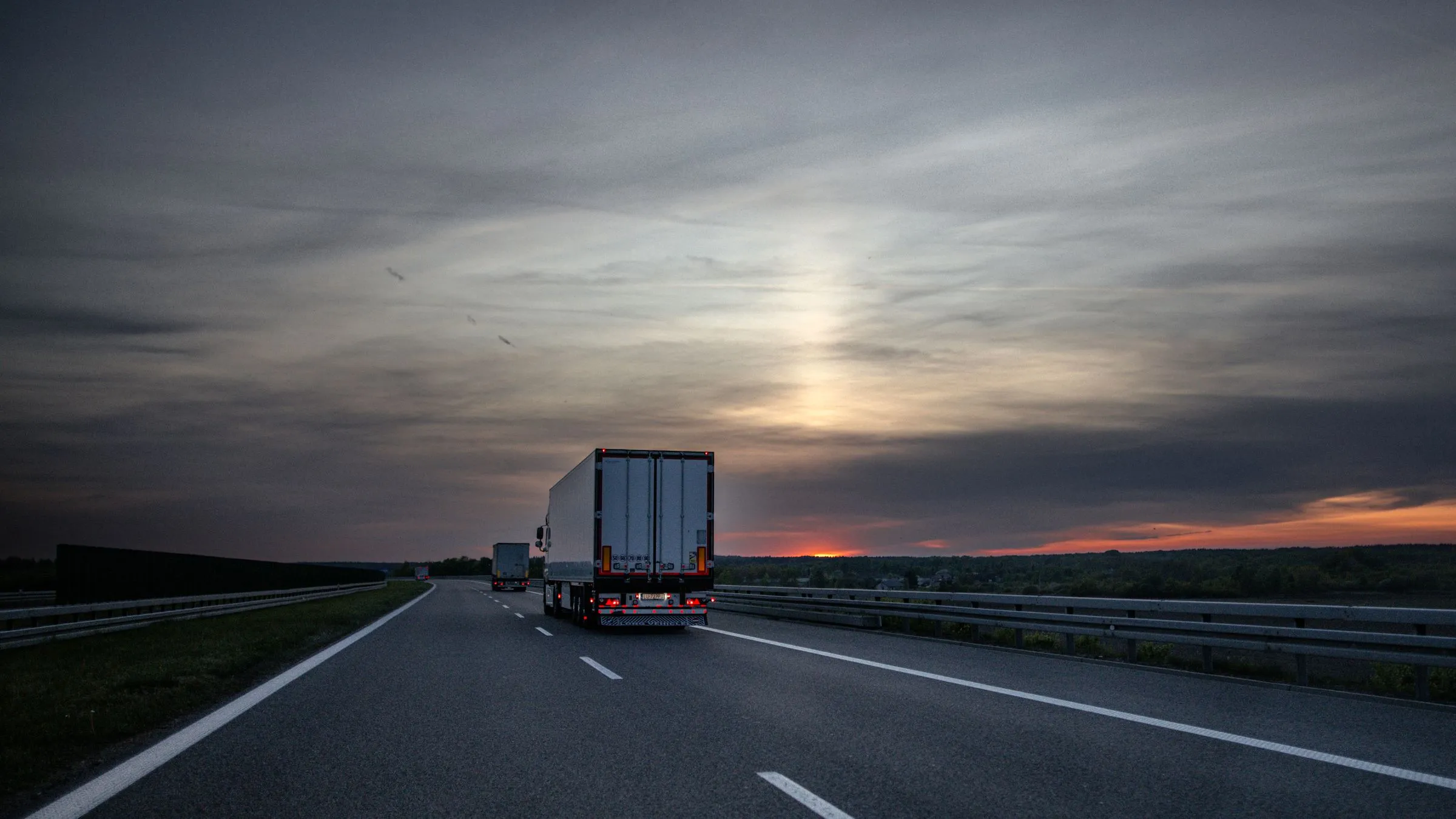 A truck on an open road at sunset
