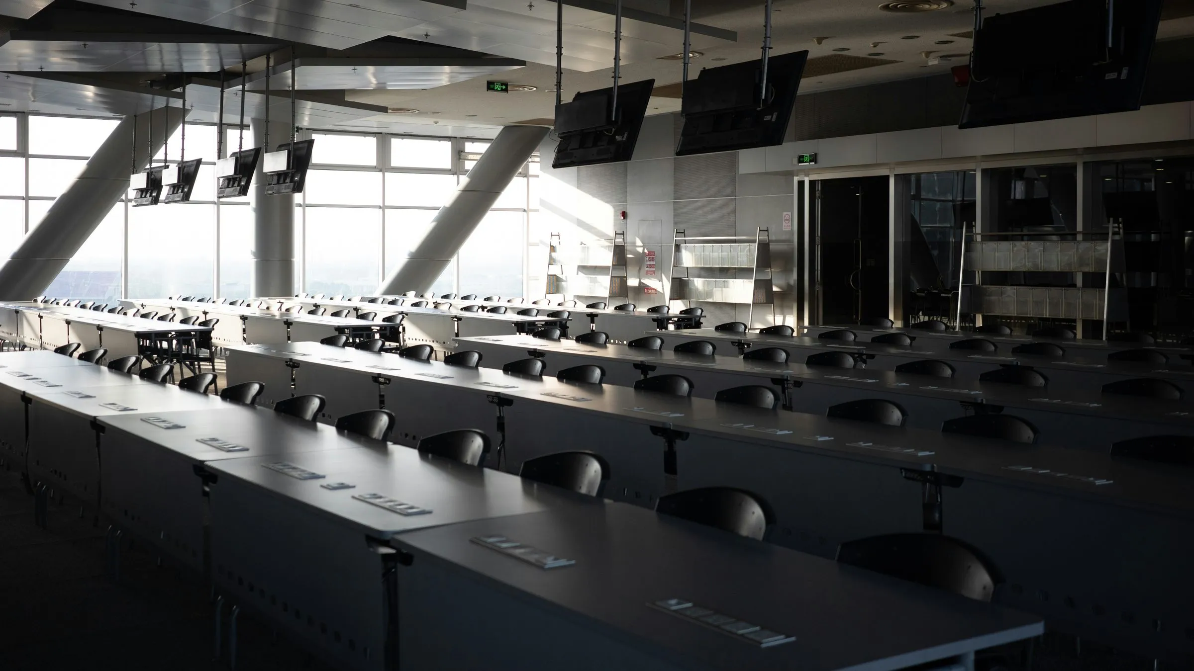 Rows of empty desks in a bright conference room