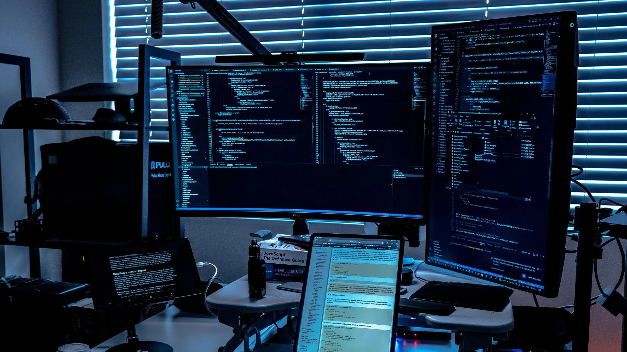 Several monitors showing code in a dark room